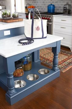 a kitchen island with dog bowls and a tote bag on it