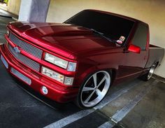 a red pick up truck parked in a parking lot