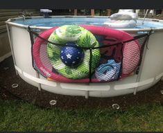 an above ground swimming pool with various items in the bottom half and mesh netting around it