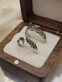 two silver rings sitting in a wooden box