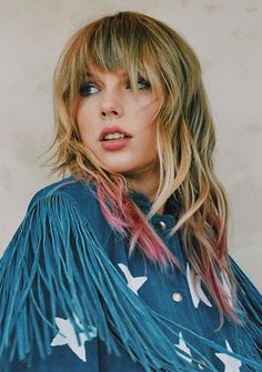 a woman with blonde hair wearing a blue jacket and white birds on it's sleeves