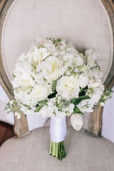 a bouquet of white flowers sitting on top of a chair