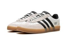 The Bad Bunny x adidas Gazelle Indoor “Off White” is a collaboration on the retro indoor soccer style by the ultra-popular international recording artist.  Bad Bunny and adidas’s partnership began with a bang with the debut of the adidas Forum Buckle Low in 2021.  Since then, the pair has released several high-profile sneakers, including this Gazelle Indoor in versatile “Off White. ” The upper has an Off White leather design with grey hairy suede overlays on the toe and heel.  Oversized black leather Three Stripes branding appears on either side of the shoe, while “adidas” “Benito” stamps can be seen on the lateral side of the mid-panel.  White rope-style laces are layered over the black tongue.  A semi-translucent Gum rubber sole completes the look. Stripes Branding, Soccer Style, Black Tongue, Adidas Gazelle Indoor, Bunny Logo, Adidas Three Stripes, Adidas Forum, Indoor Soccer, Off White Shoes