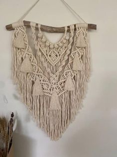 a macrame hanging on a wall with tassels