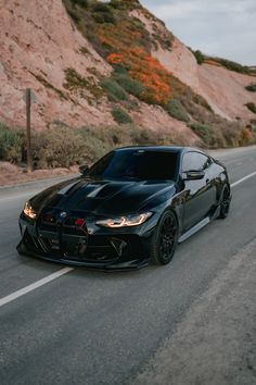 a black sports car driving down the road