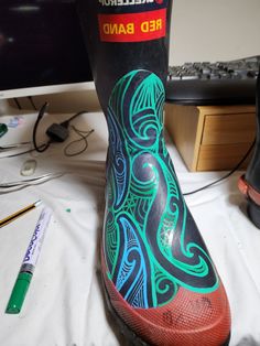 an artistically painted boot sits next to a computer keyboard