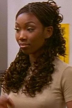 a woman with long curly hair standing in front of a mirror