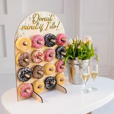 a table topped with lots of donuts next to a vase filled with flowers