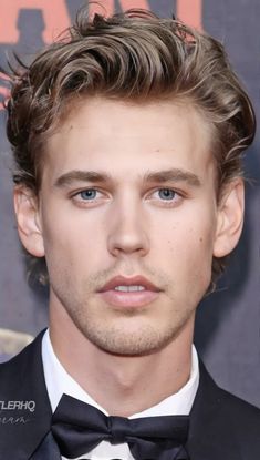 a close up of a person wearing a suit and bow tie