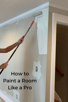 a man is painting the wall with a paint roller and an advertise that says how to paint a room like a pro