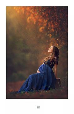 a woman is laying down in the grass with her eyes closed and she is wearing a blue dress