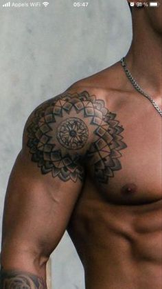 a shirtless man with tattoos on his chest and arm is looking at the camera