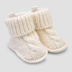 a pair of white knitted baby booties