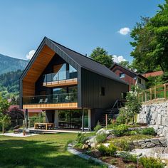 a large house with a sloping roof and glass windows on the top floor is surrounded by lush green trees