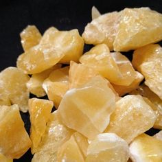 chunks of yellow sugar sitting on top of a black surface