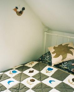 a bed with two pillows on top of it in a room that has white walls