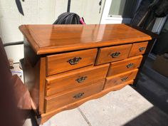 a wooden dresser sitting on top of a sidewalk