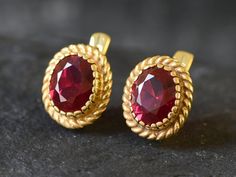 Gold Ruby Earrings set with a Created Ruby in a flawless diamond cut at 10x8mm (6 Cts a pair).Gold Vermeil: 18k Gold over Solid 925 Sterling Silver ☞ made to last.Click here for ☞ Matching RingClick here for ☞ Matching PendantDetails:• Created Ruby in a flawless clarity• Ruby: 10x8mm, 6 Ct a pair, diamond cut• Lever Back Closure - "English Lock"• Length 15mm, Width 12mm• 18k Gold VermeilSKU 2350 Ruby And Gold Earrings, Ruby Sets Indian Gold, Oval Gemstone Clip-on Earrings For Gifts, Gold Ruby Earrings, Couple Rings Gold, Gold Kada, Ruby Earring, Ruby Earrings Studs, Gold Earrings Models