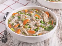 two white bowls filled with chicken and rice soup