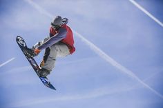 a man flying through the air while riding a snowboard