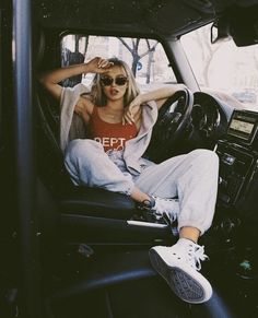 a woman sitting in the driver's seat of a car