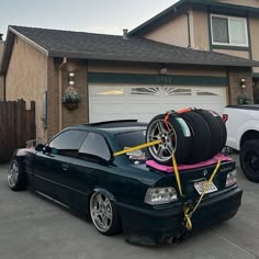 a car with some tires on it parked in front of a house