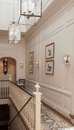 a staircase with chandeliers and pictures on the wall