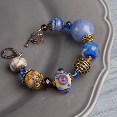 "This Lavender boho bracelet bracelet is a perfect gift for women. It's very tender and unique! This lampwork bracelet fits a 15.5-16.5cm (6.1\"-6.5\" inch) diameter wrist. If you need bigger or smaller size bracelet, please, write me the diameter of your wrist when making an order. Dimentions: 21cm. Materials: artist lampwork beads, metal and glass beads, metal fittings. Colors used: blue, lavender, lilac. Please, note, each lampwork bead is made by hand and may differ slightly. All the photos Boho Beaded Jewelry, Lavender Bracelet, Kawaii Bracelet, Pomegranate Earrings, Lampwork Bracelets, Ornate Jewelry, Lampwork Bead Jewelry, Multicolor Bracelet, Ice Resin