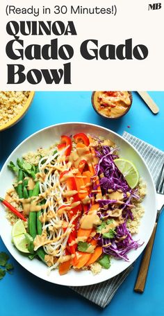 a white plate topped with salad next to a bowl of rice and vegetables on a blue table