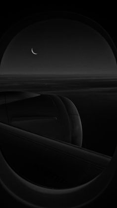 the moon is seen through an airplane window