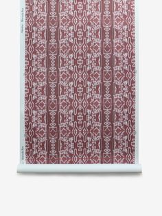 a red and white wall hanging on the side of a wall with an abstract pattern