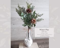 a vase filled with pine cones and greenery