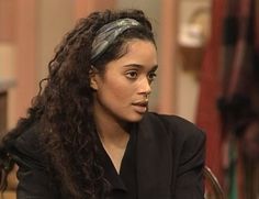 a woman with long curly hair sitting down