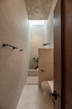 a bathroom with a toilet, sink and window in the wall next to each other