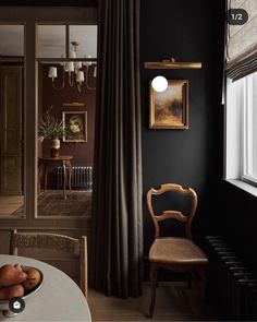 a dining room with black walls and chairs