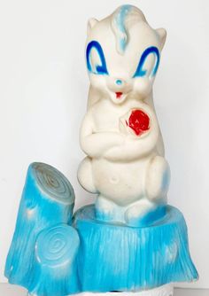 a blue and white cat figurine sitting on top of a piece of ice