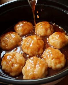 the food is being poured into the slow cooker to make dumplings in caramel sauce