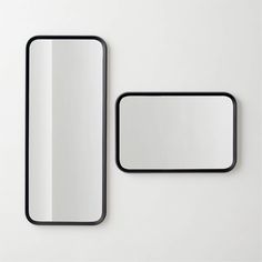 two mirrors are shown next to each other on a white surface, one is black and the other is light gray