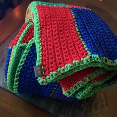 three crocheted blankets sitting on top of a wooden table next to each other