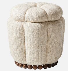 a white ottoman with wooden beads around it