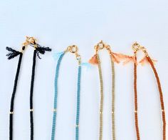 Great for everyday wear! Very tiny and delicate. Muted neutral tones. This tiny necklace is made with high quality Japanese seed beads that are perfect cylinders. Necklace clasp and jump rings are gold plated. Natural silk cord with frayed tassel ends. Available in 4 matte colors: burnt umber, palm, black, and ocean. 📏Not sure which length to choose? Add a chain extender: https://etsy.me/34lPf3m ✨ FREE SHIPPING IN THE USA ✨ 🌎 Packaging 🌎 To be environmentally responsible about packaging we wi Adjustable Gold Beaded Everyday Necklaces, Adjustable Gold Beaded Necklaces For Everyday, Minimalist Adjustable Beaded Necklace With Gold Beads, Adjustable Everyday Beaded Necklace, Adjustable Tiny Beads Necklace For Everyday, Minimalist Necklace Gold, Tiny Necklace, Matte Colors, Boho Chic Necklace