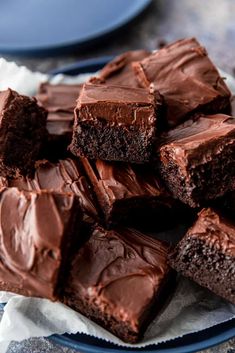 a plate full of chocolate brownies sitting on top of a blue and white napkin