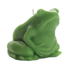 a green frog candle sitting on top of a white surface