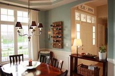 a dinning room table and chairs in front of two windows