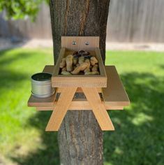 a tree stand with some rocks in it next to a small tin on the ground