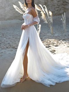 a woman in a white dress standing on the beach