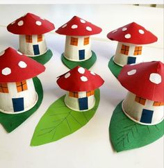 paper mushroom houses are sitting on top of green leaves