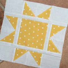 a yellow and white patchwork quilt on the ground