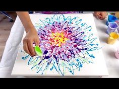 someone is painting a flower on a canvas with acrylic paint and watercolors