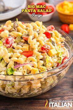 a pasta salad in a glass bowl on a wooden table